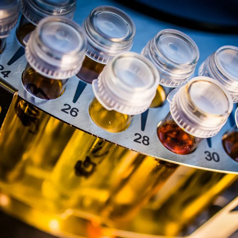 Flacons d’échantillons d’huile numérotés dans un laboratoire d’analyse industrielle.