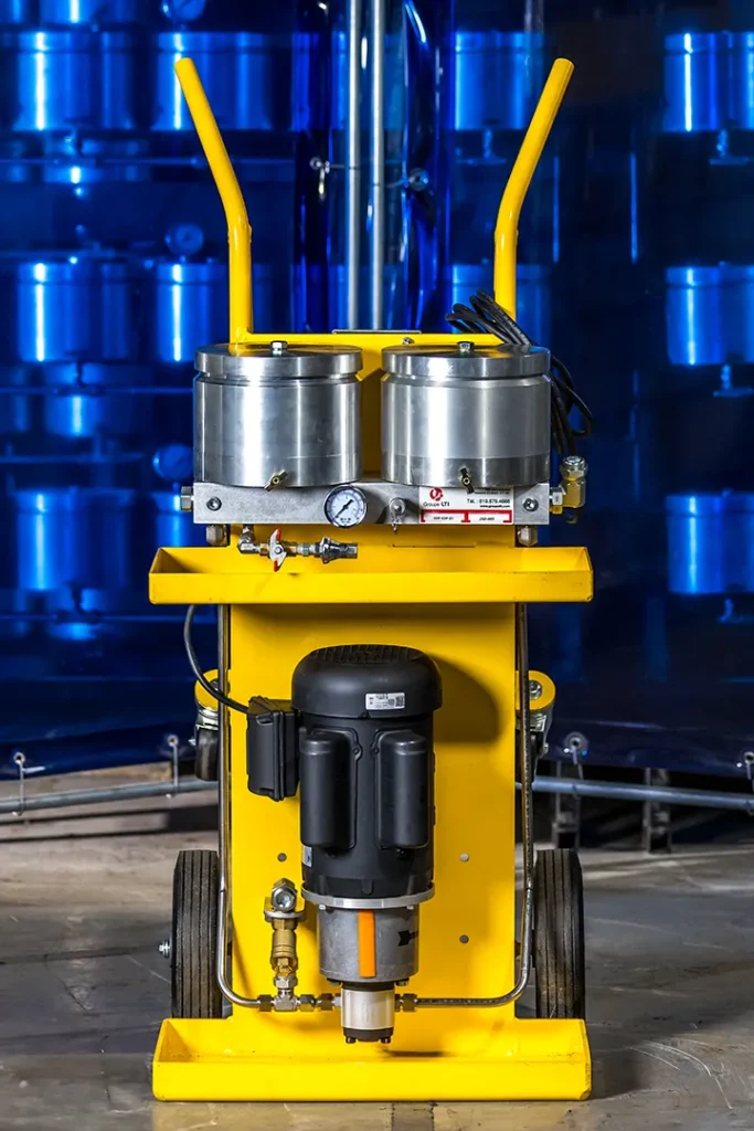 Tuyaux et cuve métallique d’un système de filtration d’huile thermique en fonctionnement dans un environnement industriel.